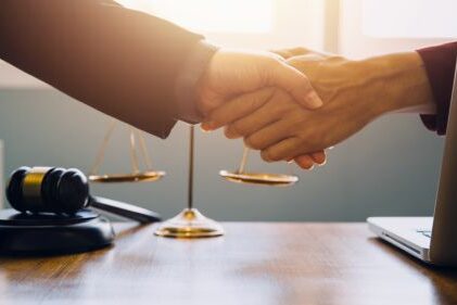 Händeschütteln mit Justizsymbolen zum Thema Arbeitsrecht